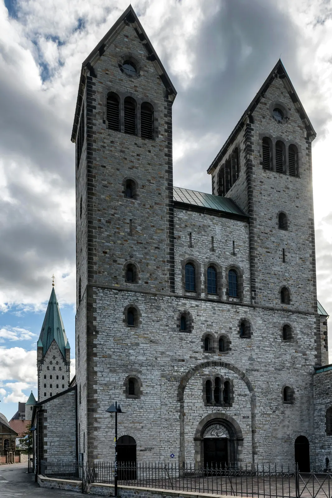 Abdinghofkirche in Paderborn mit romanischen Doppeltürmen, dahinter der Domturm.
