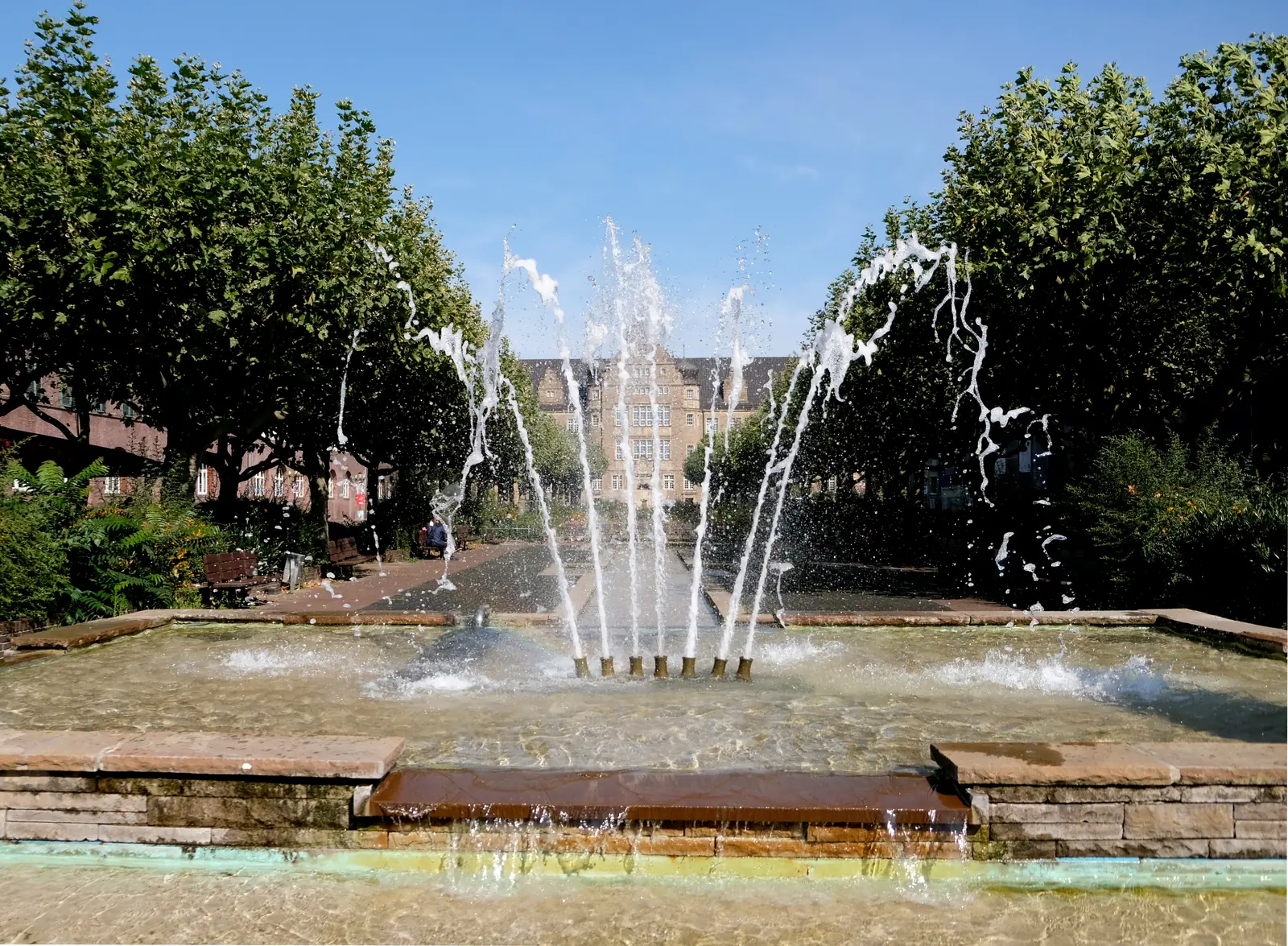 Springbrunnen auf dem Friedensplatz in Oberhausen, dahinter das Amtsgericht.