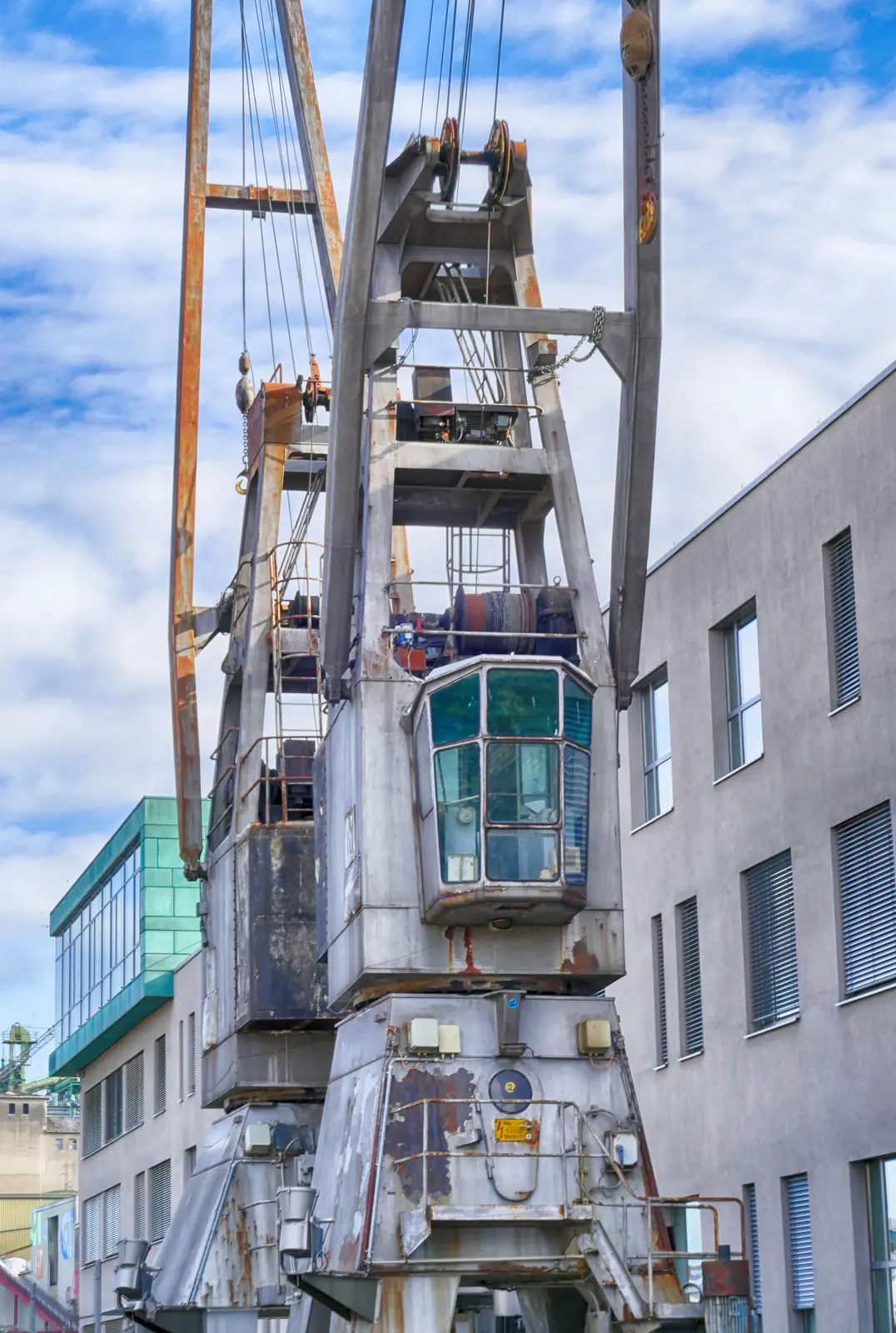 Historischer Hafenkran vor modernen Bürogebäuden im Neusser Hafen.