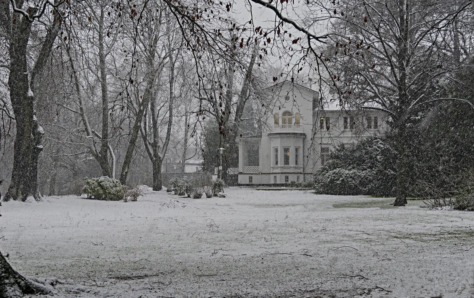 Haus Schönhausen in Krefeld-Traar bei dichtem Schneefall im winterlichen Park.
