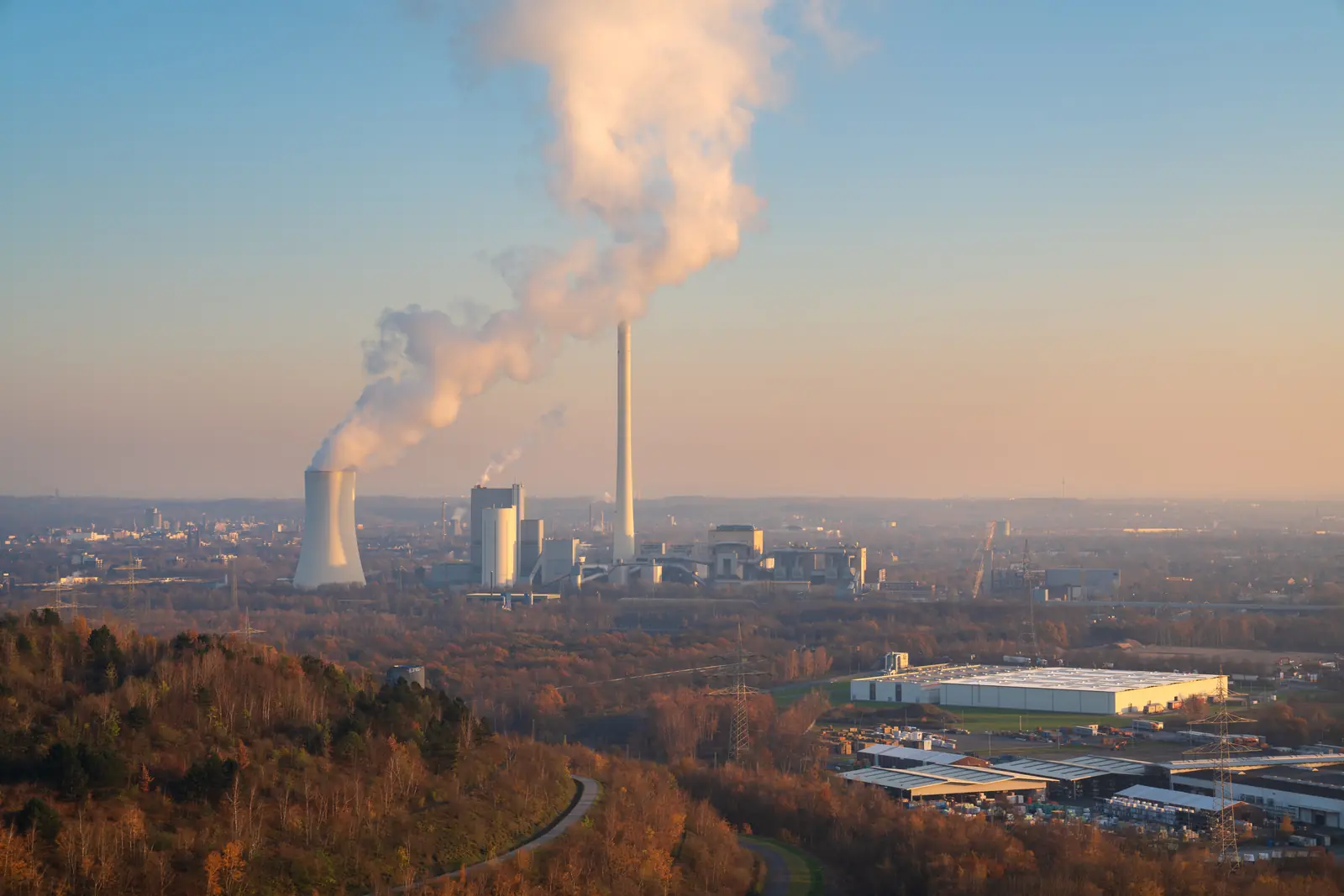 Blick von einer Halde auf das Kraftwerk Herne mit Kühlturm und Schornstein.