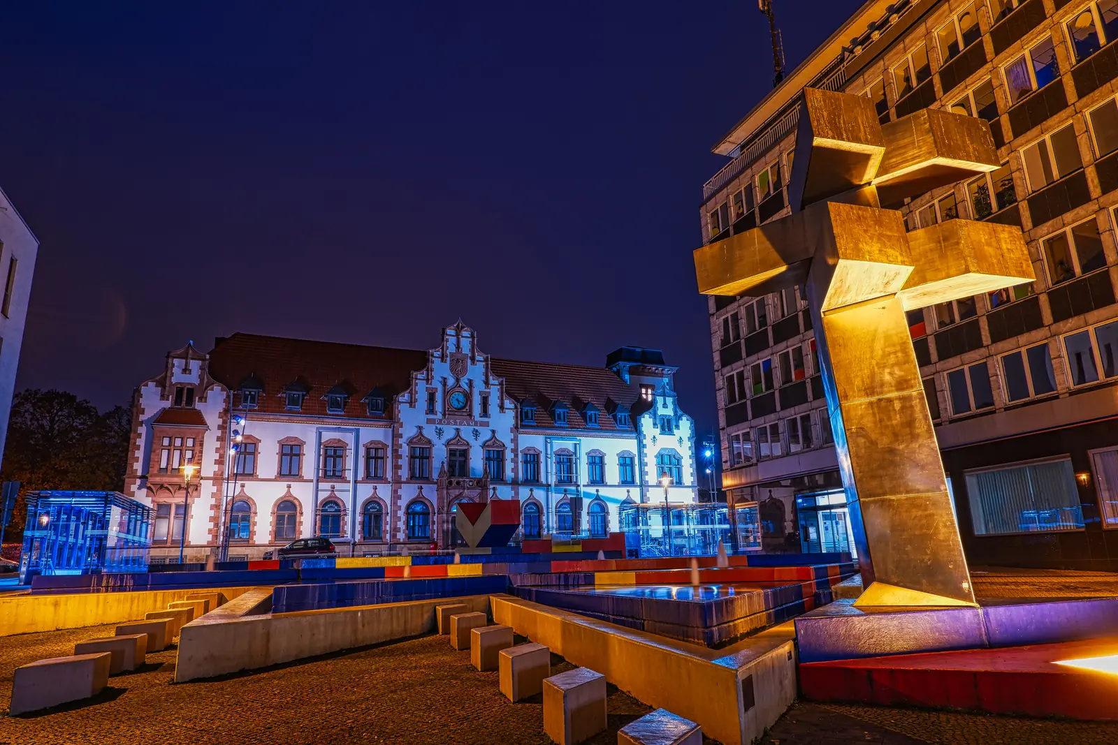 Kunstmuseum in der Alten Post in Mülheim an der Ruhr bei Nacht, davor der Hajek-Brunnen.
