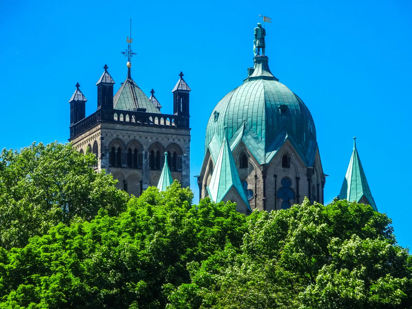 Quirinusmünster in Neuss mit grüner Kuppel und Statue des heiligen Quirinus.