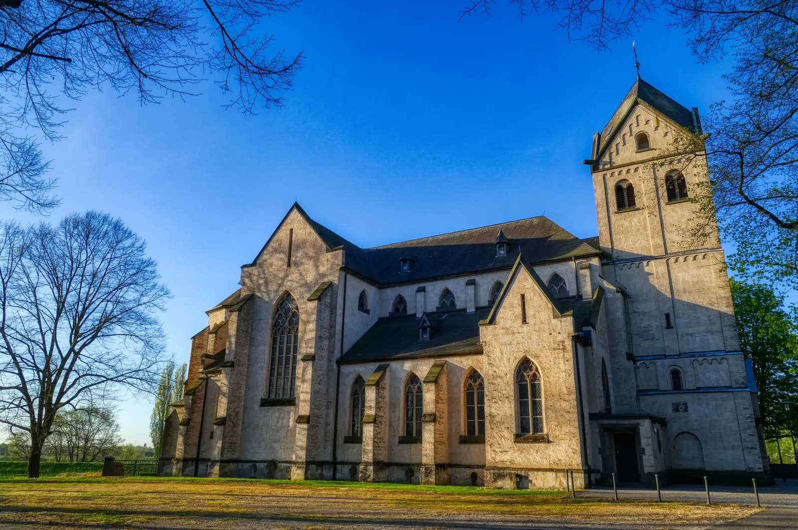 Romanische Kirche mit mächtigem Glockenturm im Abendlicht in Krefeld.