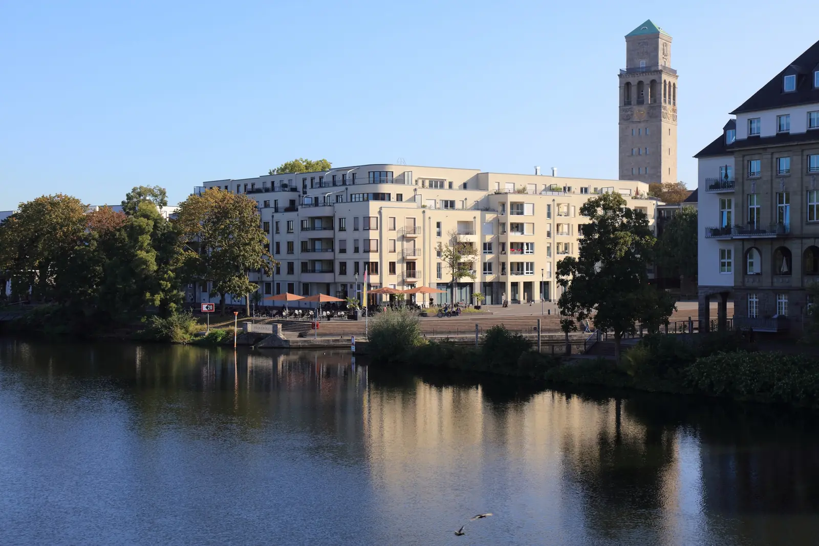 Ruhrufer in Mülheim an der Ruhr mit modernen Wohnhäusern und historischem Rathausturm.