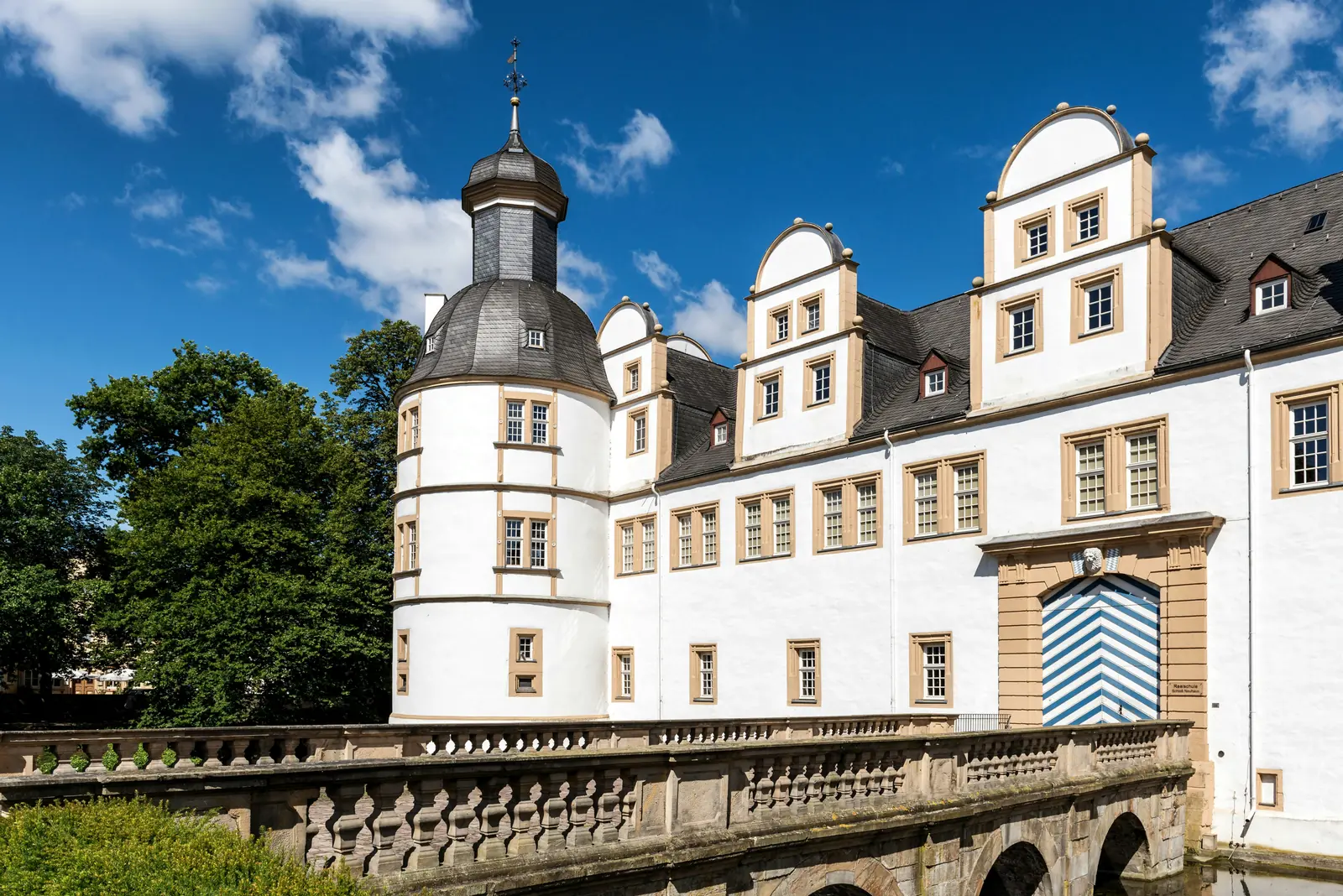 Eckturm und Portal von Schloss Neuhaus in Paderborn mit Balustradenbrücke.