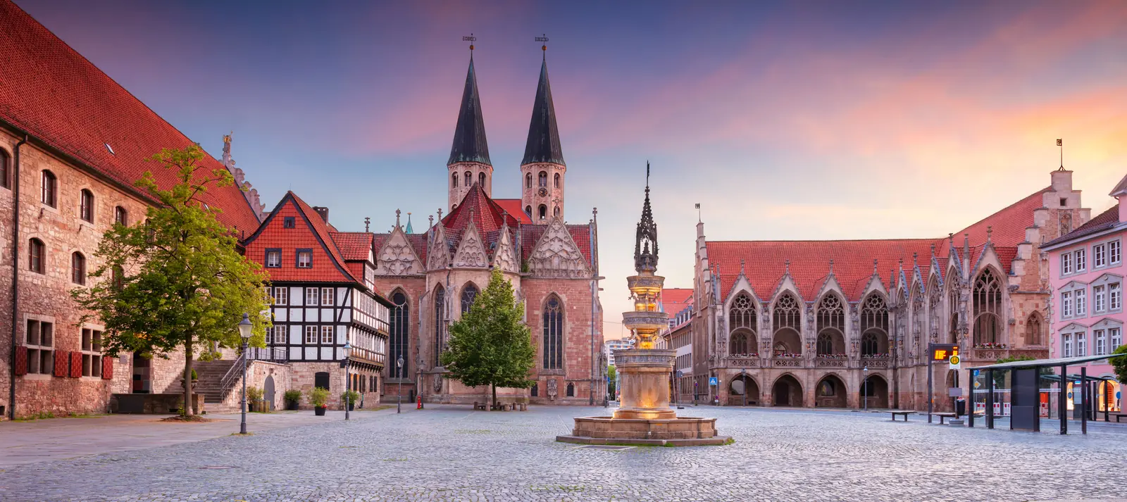 Altstadtmarkt in Braunschweig mit Martinikirche, Altstadtrathaus und Marienbrunnen bei Sonnenaufgang.