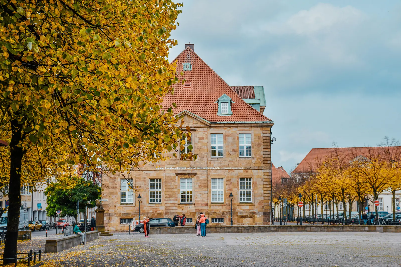 Bischöfliche Kanzlei in Osnabrück hinter herbstlich gelben Linden.