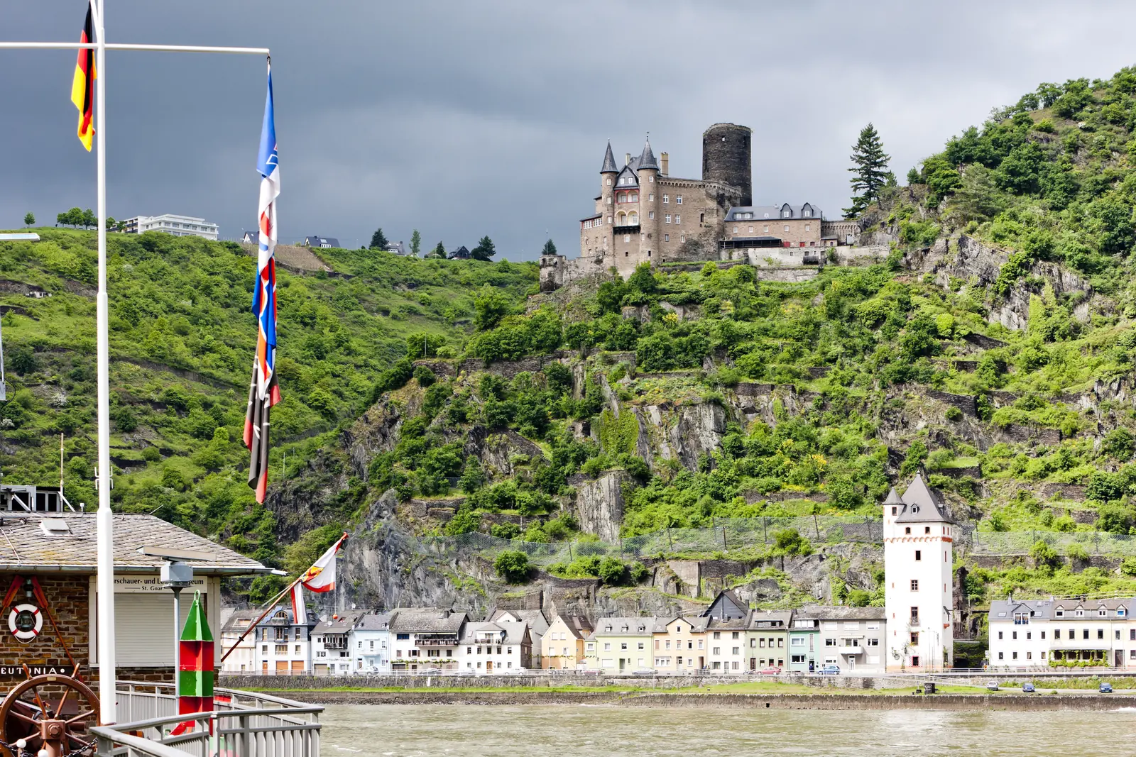 Burg Katz über St. Goarshausen am Rhein, im Vordergrund Flaggen eines Ausflugsschiffs.