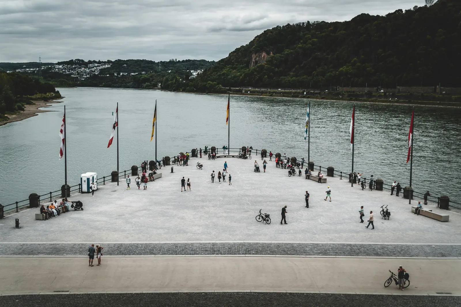 Aussichtsplattform am Deutschen Eck in Koblenz mit Fahnenreihe und Blick auf den Rhein.