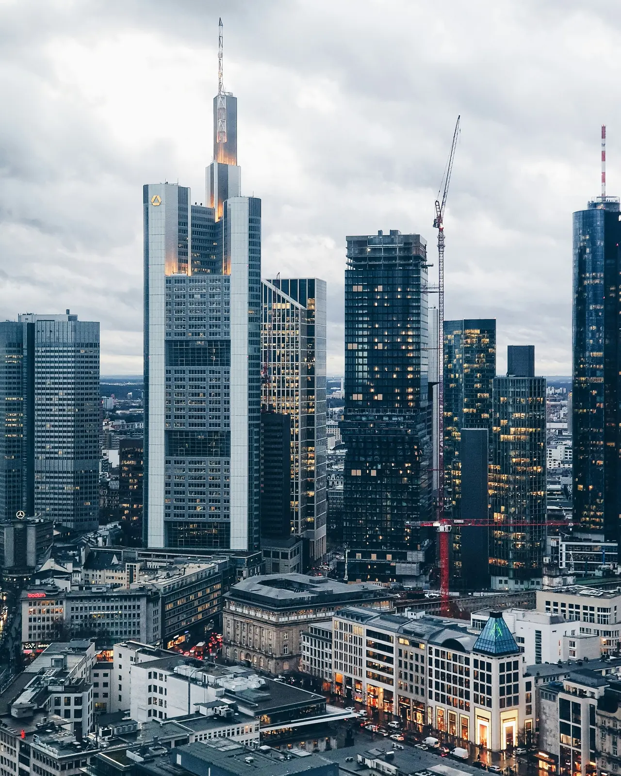 Hochhäuser des Frankfurter Bankenviertels mit dem Commerzbank Tower an einem grauen Tag.