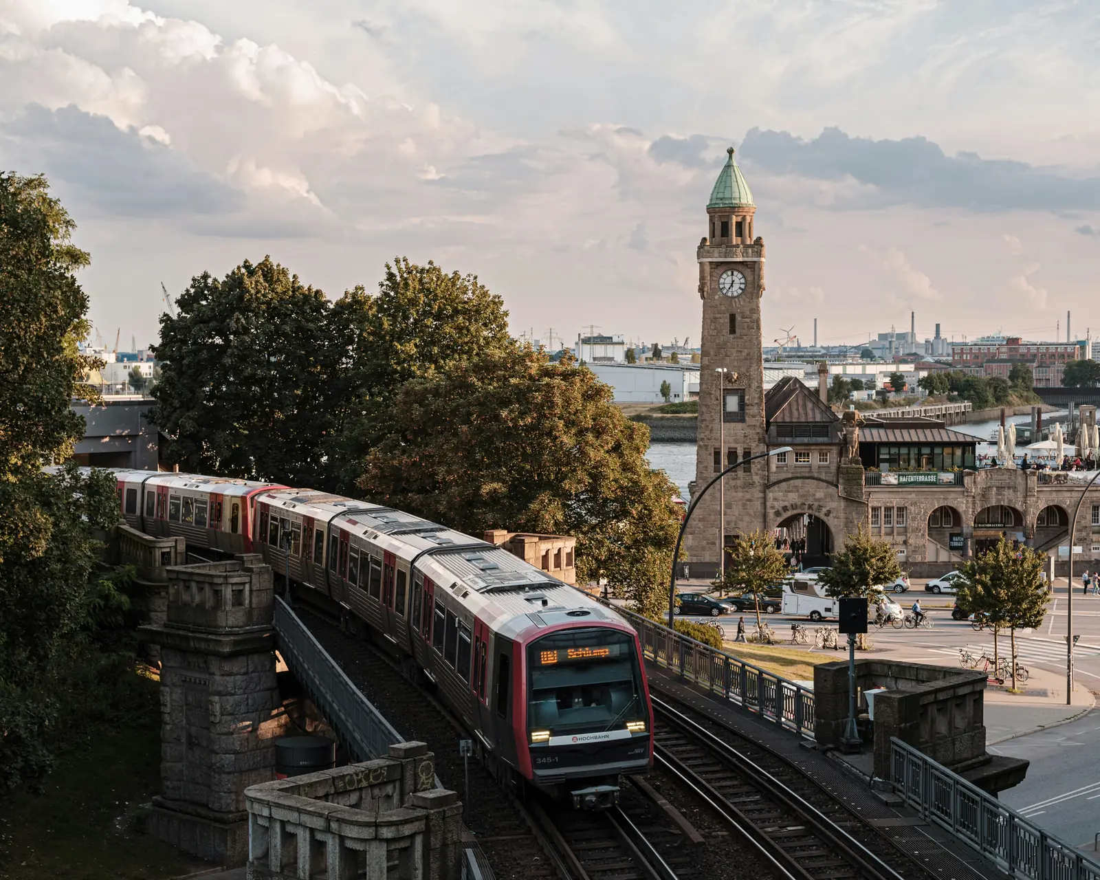 Hochbahn fährt an den Landungsbrücken in Hamburg vorbei, dahinter der Pegelturm.