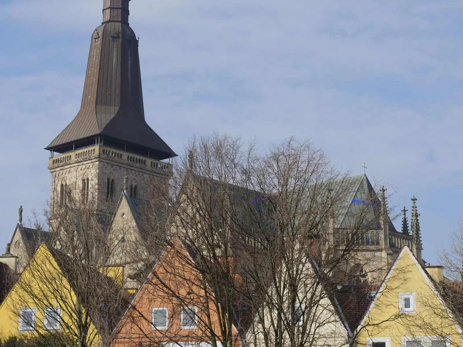 Hoher Kirchturm über den bunten Giebeln der Osnabrücker Altstadt.