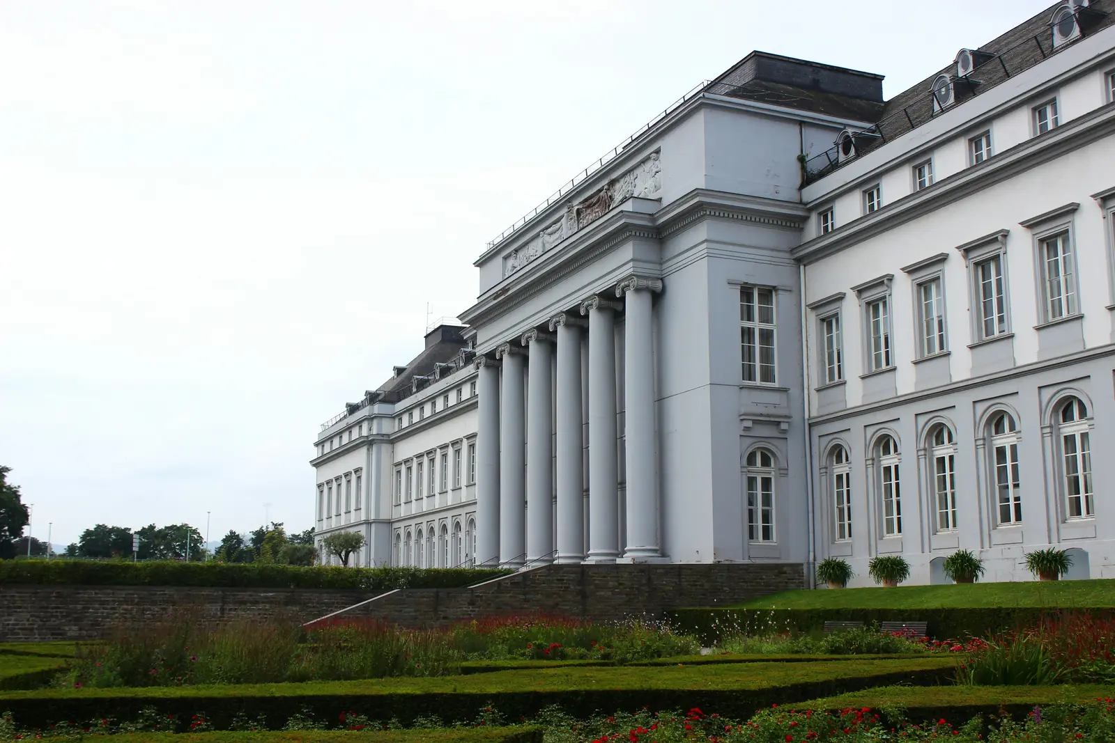 Kurfürstliches Schloss in Koblenz mit Säulenportikus und Blumenbeeten davor.