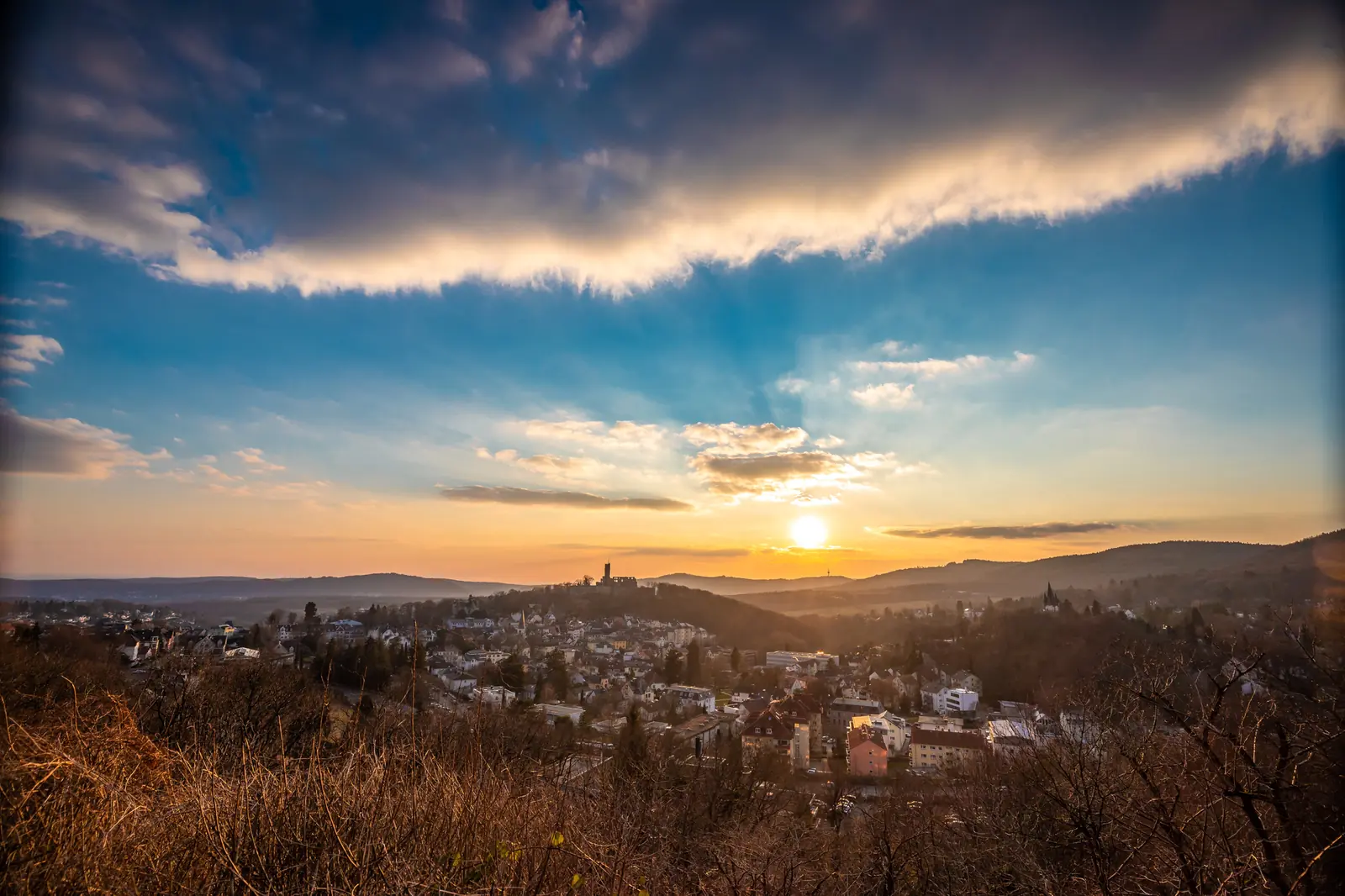 Löwenburg im Bergpark Wilhelmshöhe zwischen frühlingsgrünen Bäumen.