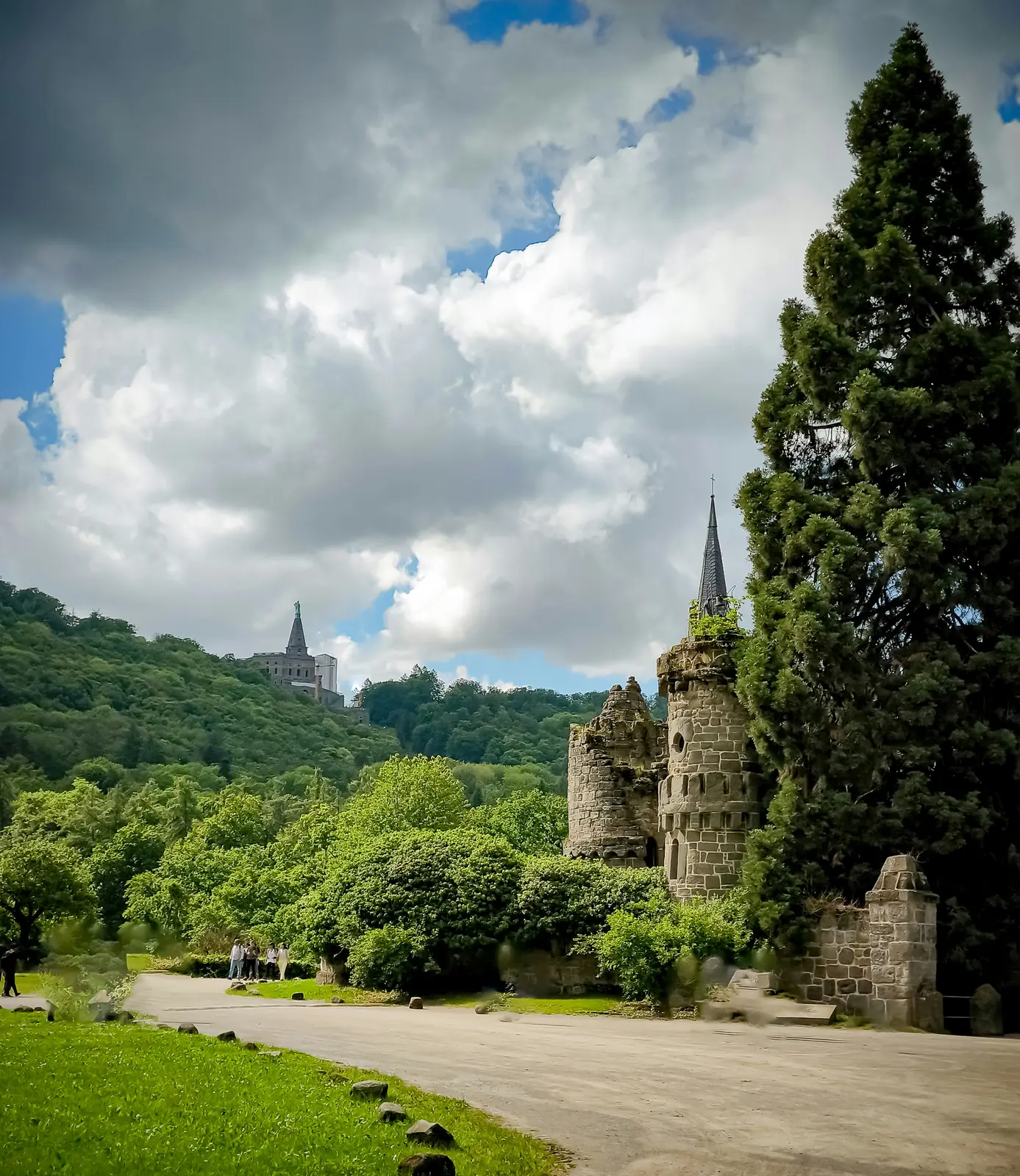 Türme der Löwenburg im Bergpark Wilhelmshöhe unter dramatischem Wolkenhimmel.