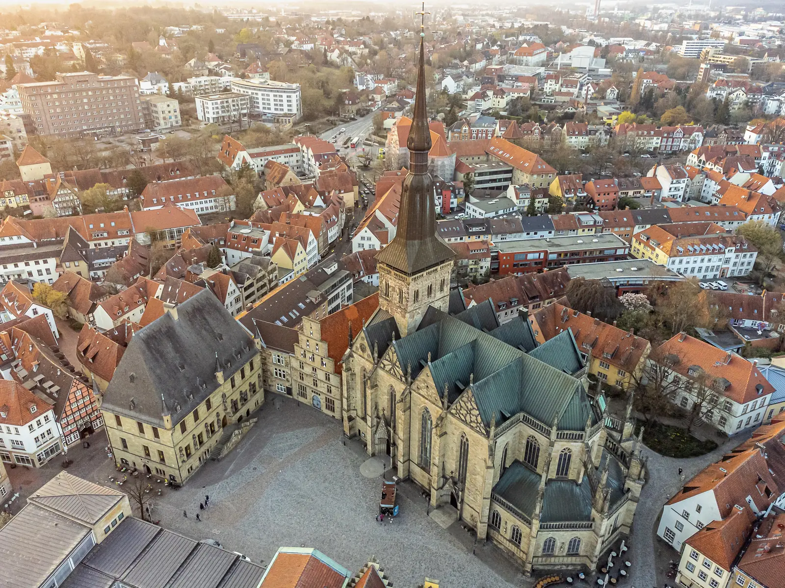 Luftaufnahme des Osnabrücker Marktes mit Rathaus und großer gotischer Kirche.