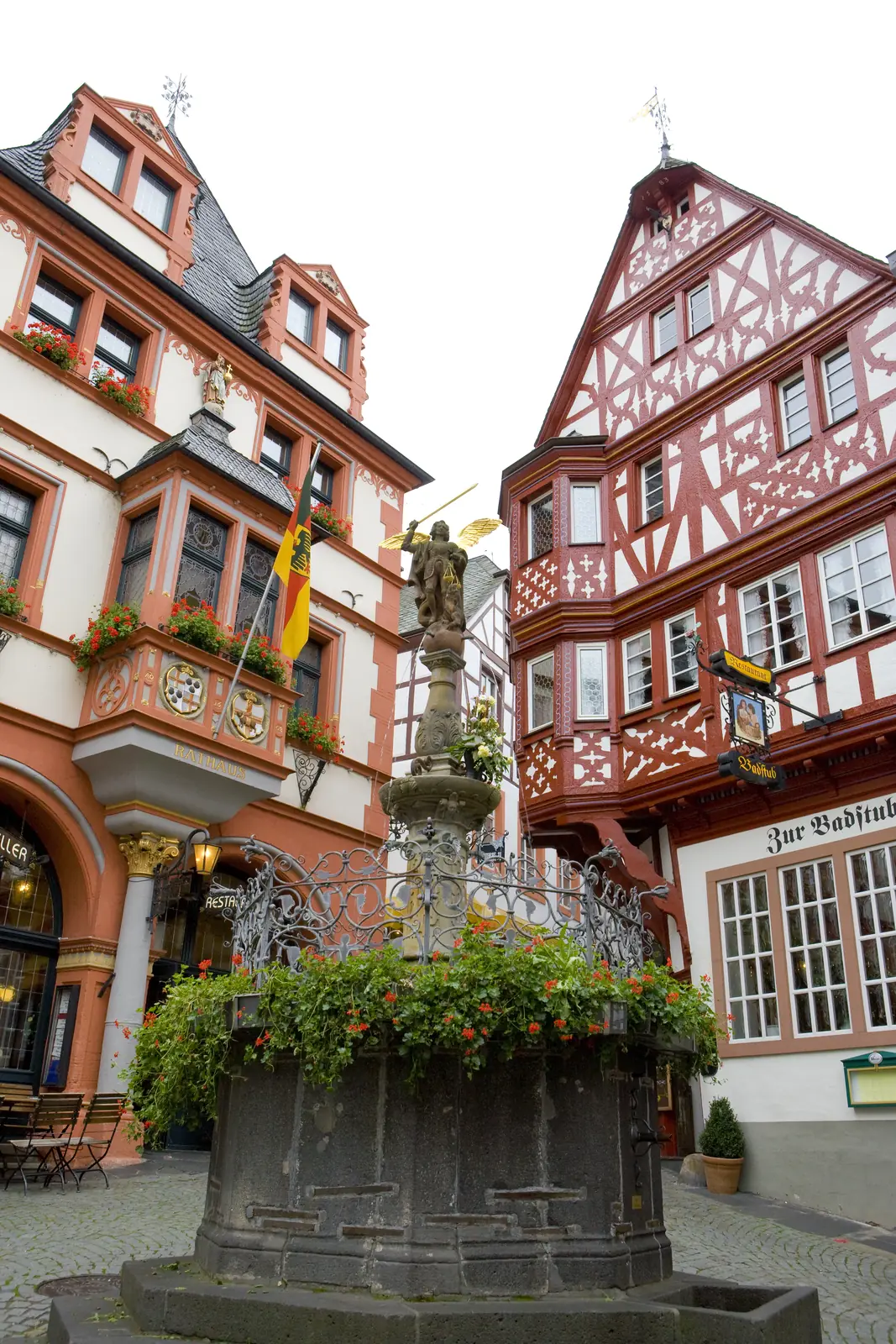 Michaelsbrunnen auf dem Marktplatz von Bernkastel-Kues zwischen Fachwerkhäusern.