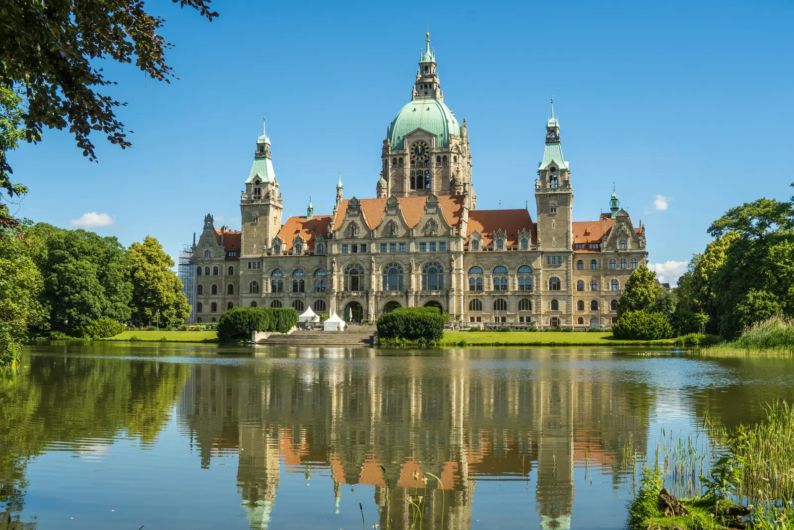 Neues Rathaus in Hannover spiegelt sich im Maschteich im Sommer.