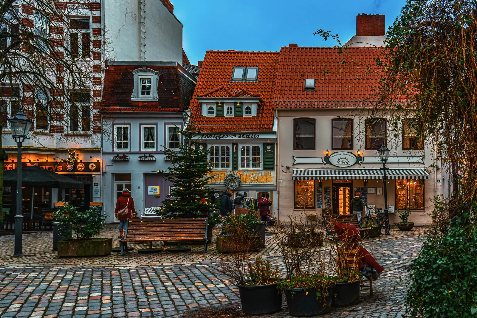 Gasse im Schnoorviertel in Bremen mit historischen Häusern und geschmücktem Tannenbaum.
