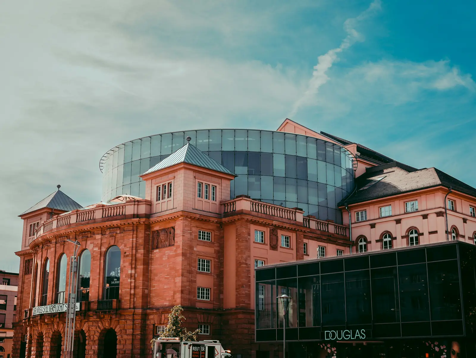 Staatstheater Mainz mit gläsernem Rundbau über dem historischen Sandsteinsockel.