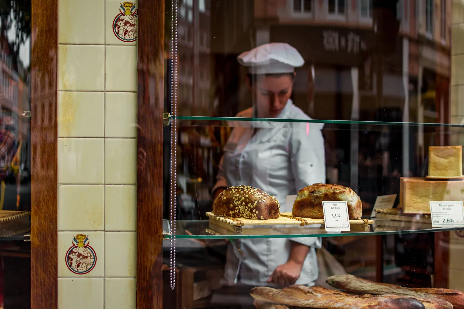 Betriebsmittelprüfung und Leiter- und Trittprüfung in der Bäckerei: Verkäuferin hinter der Schaufensterauslage.