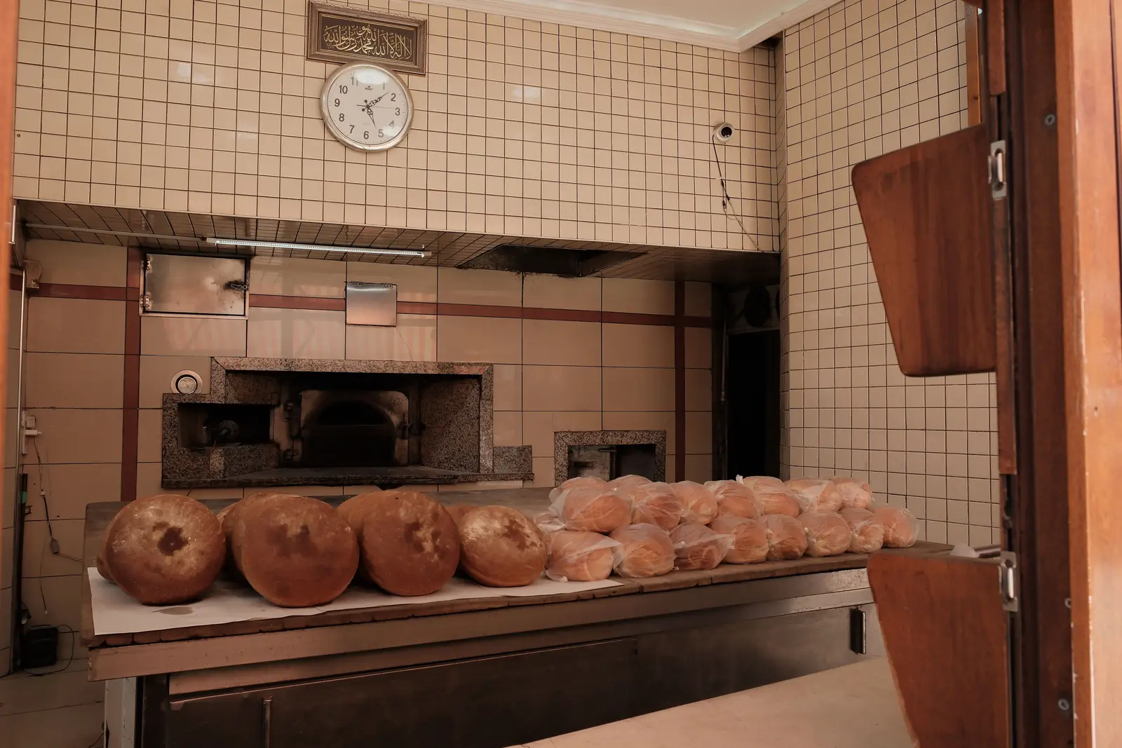 Betriebsmittelprüfung in der Bäckerei: Backofen und frische Brotlaibe in der Backstube.