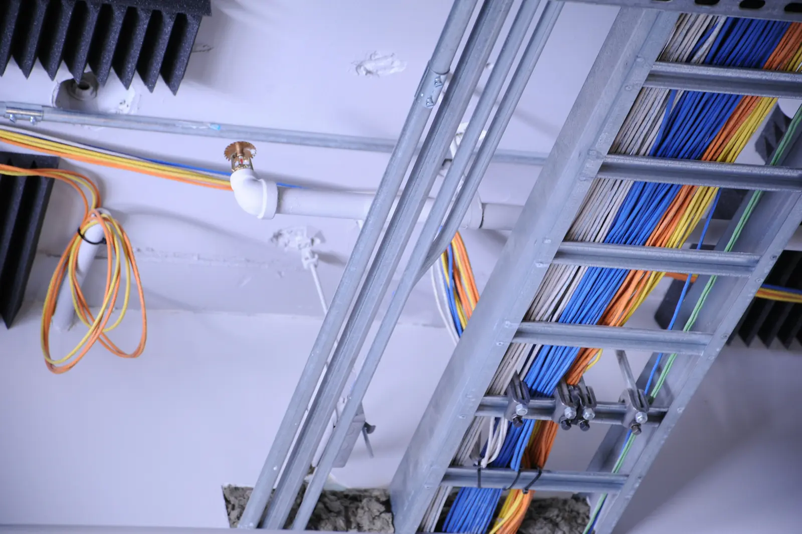 Betriebsmittelprüfung im Facility Management: Kabeltrassen und Leitungen unter der Decke.