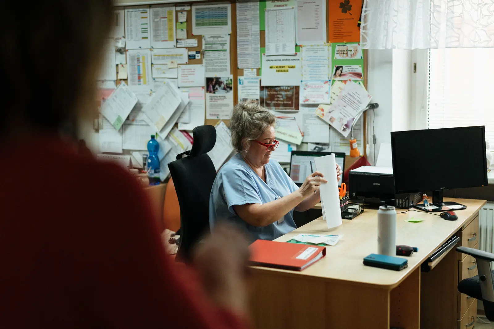 Betriebsmittelprüfung im Pflegeheim: Arbeitsplatz mit Monitor und Drucker im Stationszimmer.