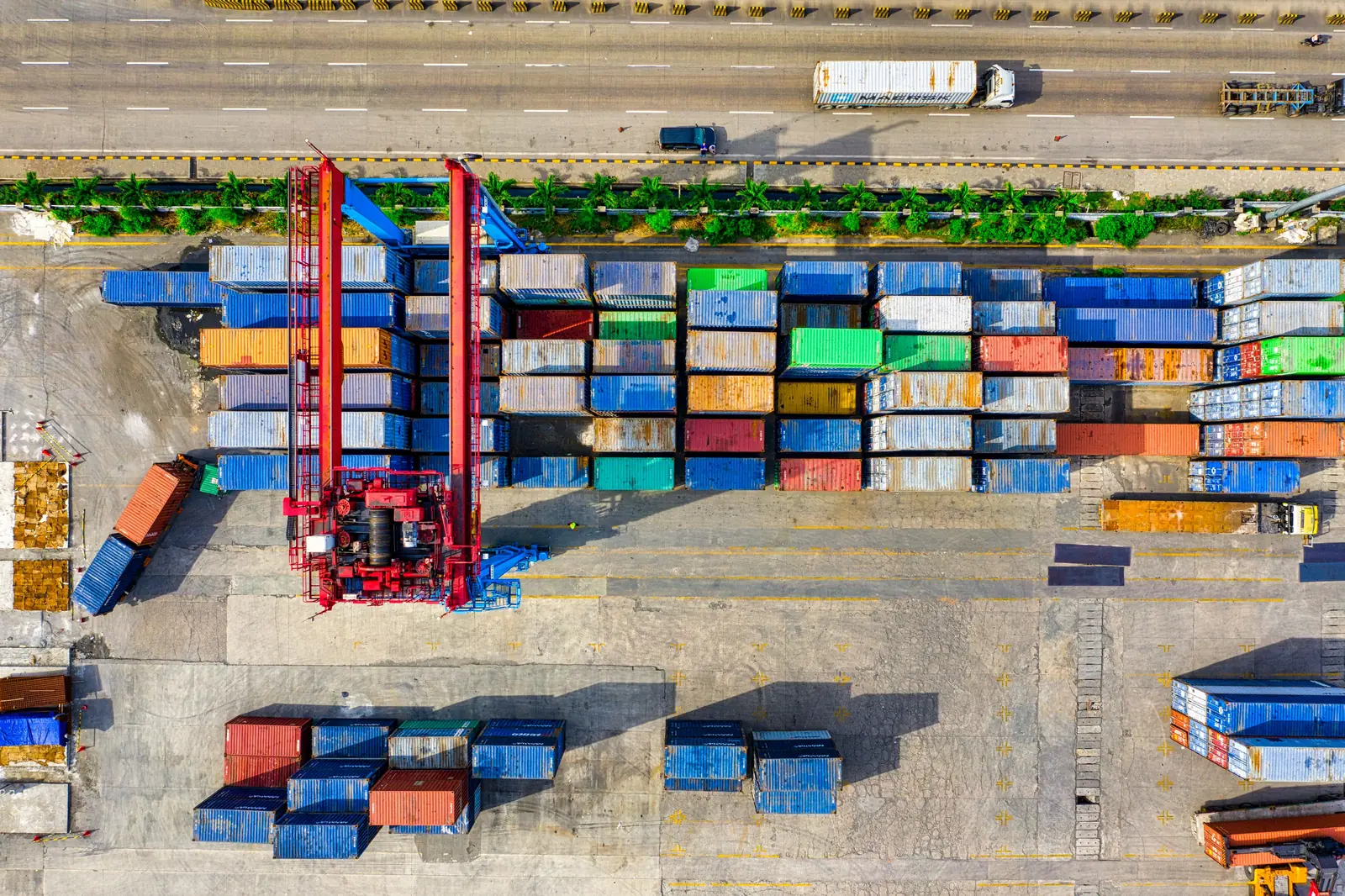 Betriebsmittelprüfung in der Spedition: Portalhubwagen über den Containerreihen.