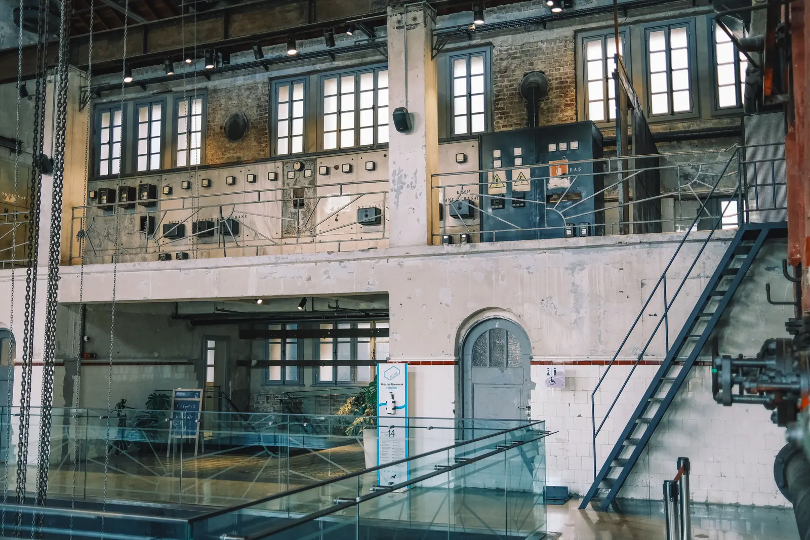 Betriebsmittelprüfung bei den Stadtwerken: Alte Schaltwarte mit Messgeräten über der Maschinenhalle.