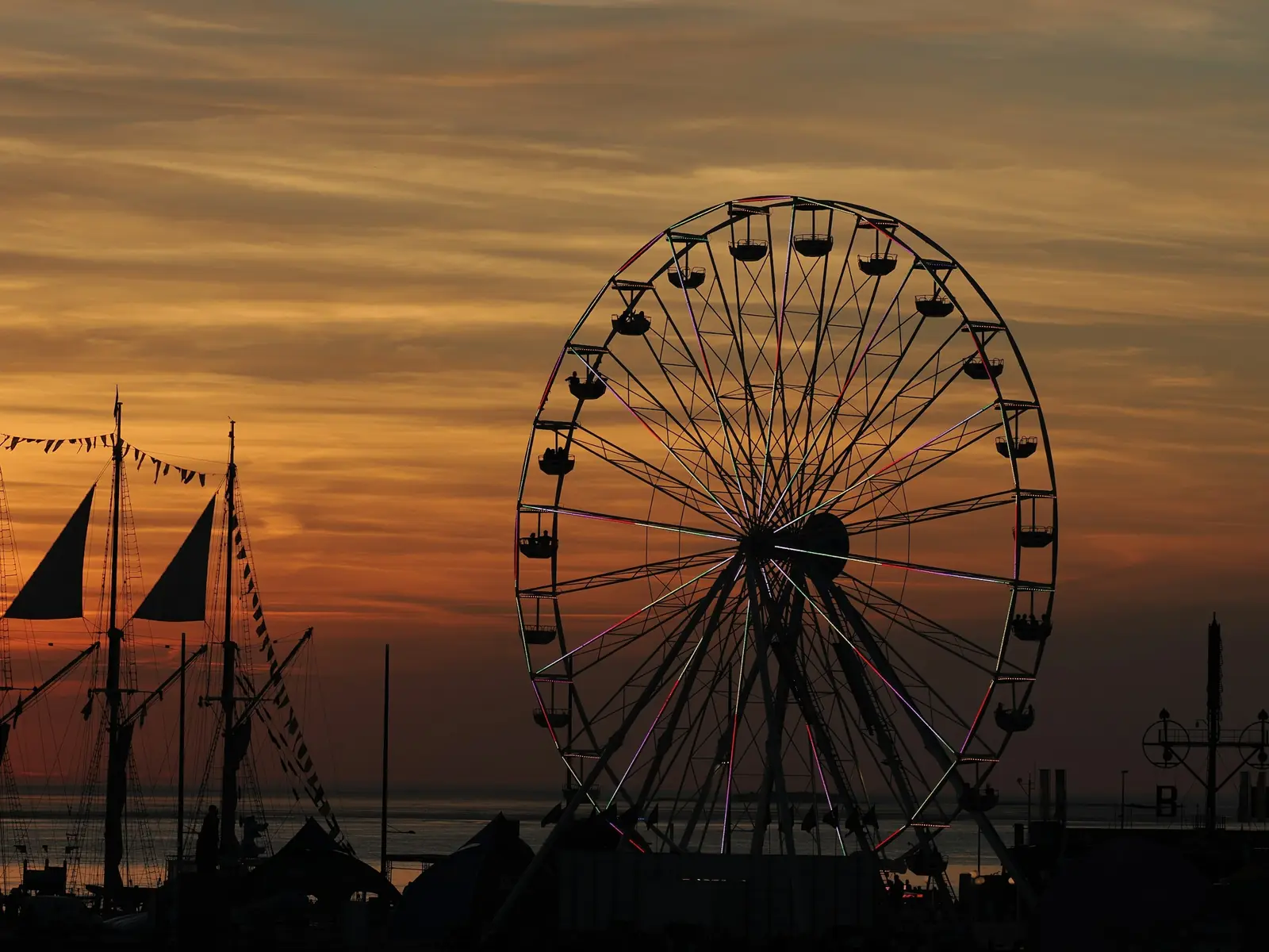 Betriebsmittelprüfung und Leiter- und Trittprüfung in Bremerhaven: Riesenrad und Masten im Abendrot.