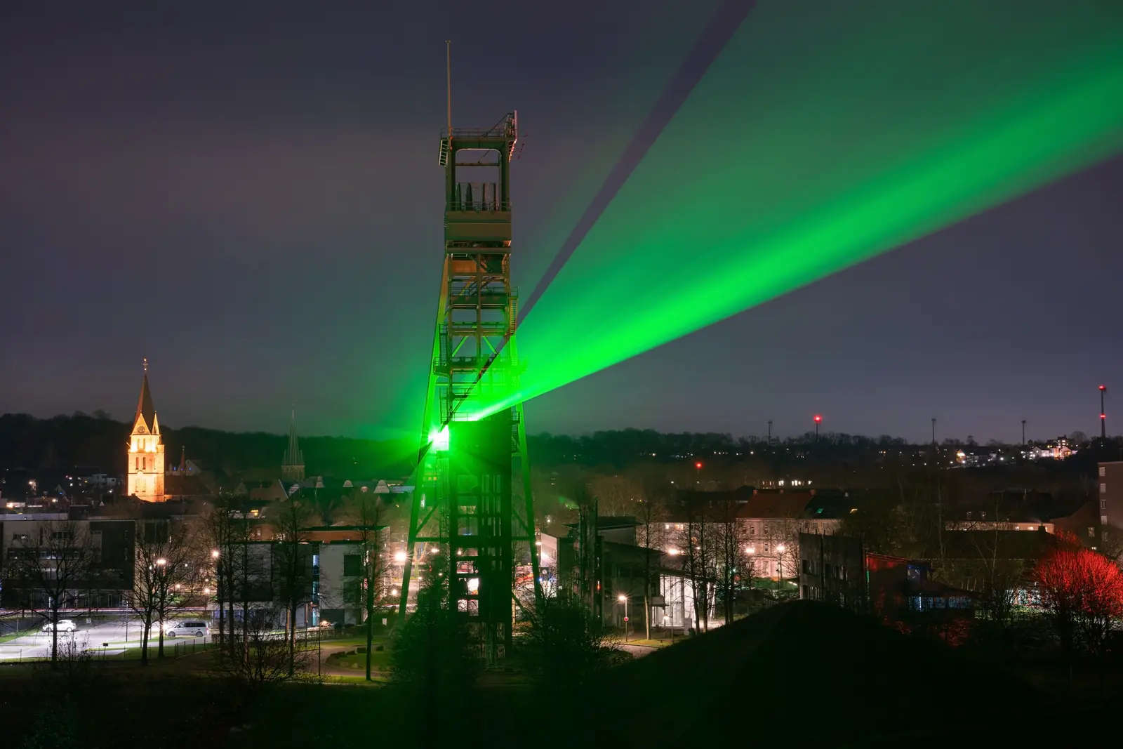 Betriebsmittelprüfung und Leiter- und Trittprüfung in Castrop-Rauxel: Grünes Fördergerüst mit Lichtstrahlen.