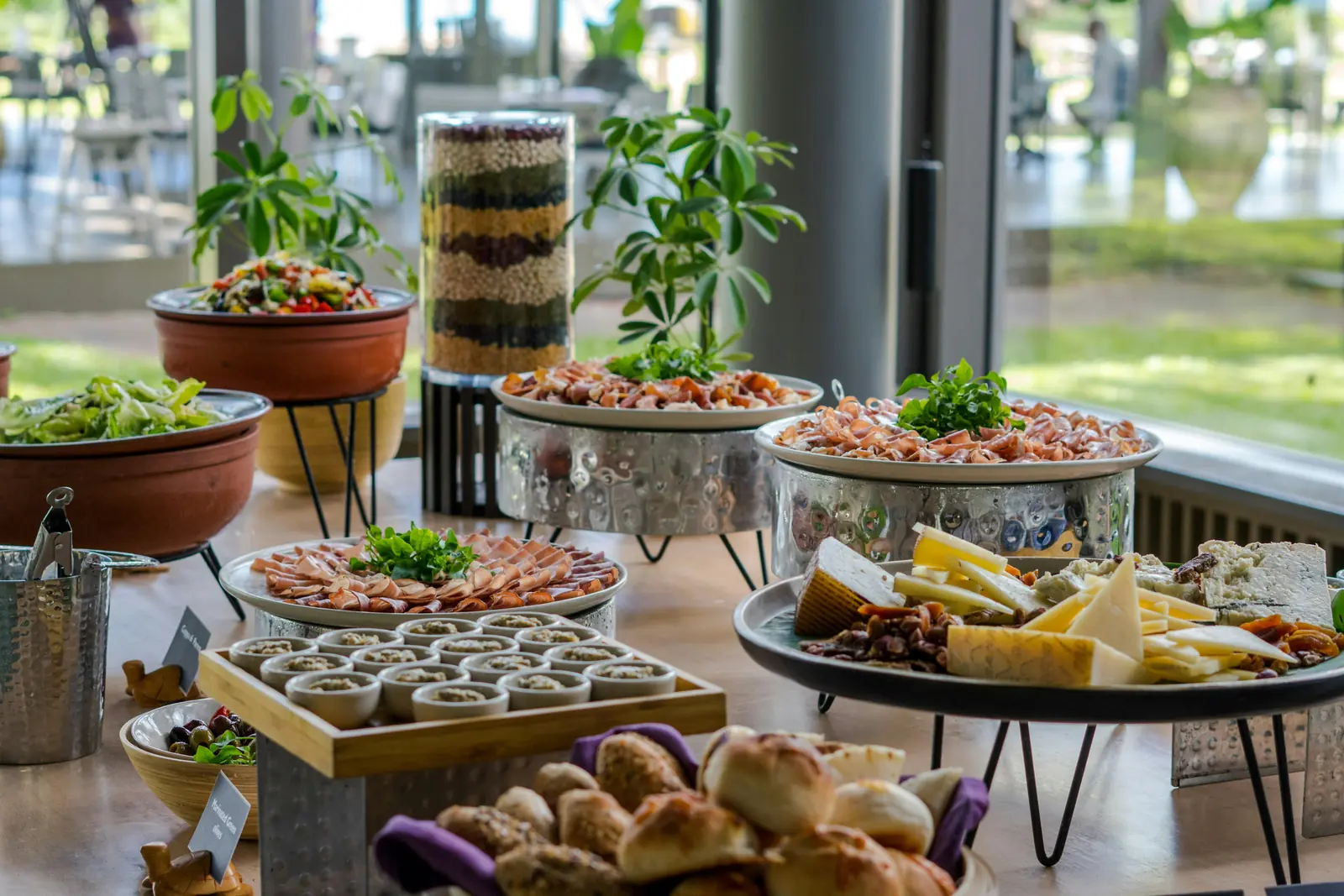 Betriebsmittelprüfung und Leiter- und Trittprüfung im Catering: Buffet mit Salaten, Käse und Gebäck.