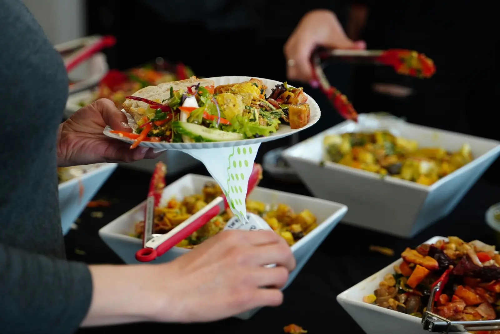 Betriebsmittelprüfung und Leiter- und Trittprüfung im Catering: Gäste füllen sich am Buffet auf.