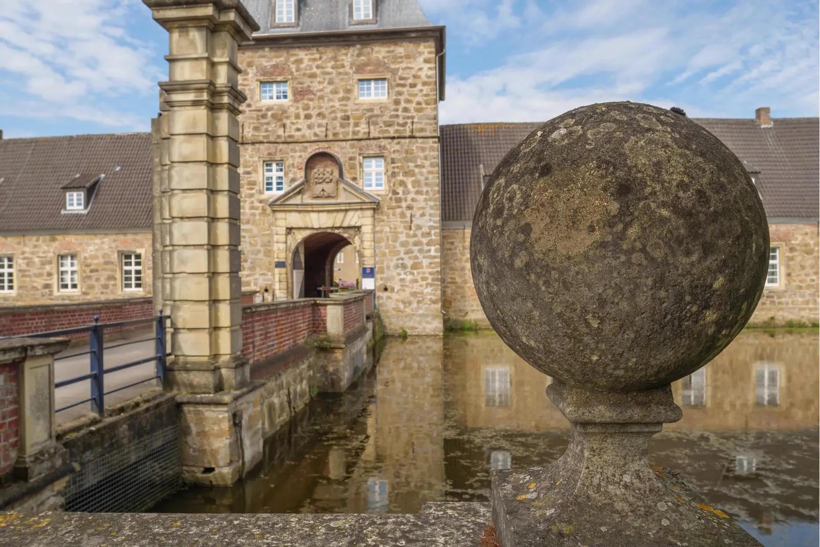 Betriebsmittelprüfung und Leiter- und Trittprüfung in Dorsten: Steinkugel auf der Brüstung vor dem Torhaus.