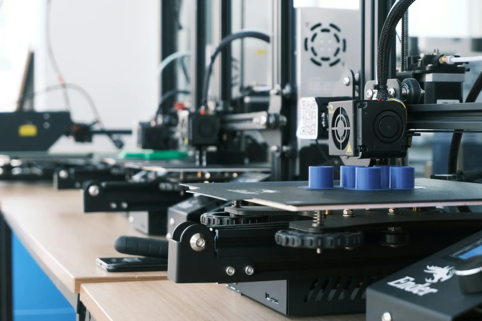Betriebsmittelprüfung und Leiter- und Trittprüfung in der Druckerei: Reihe von 3D-Druckern auf der Werkbank.