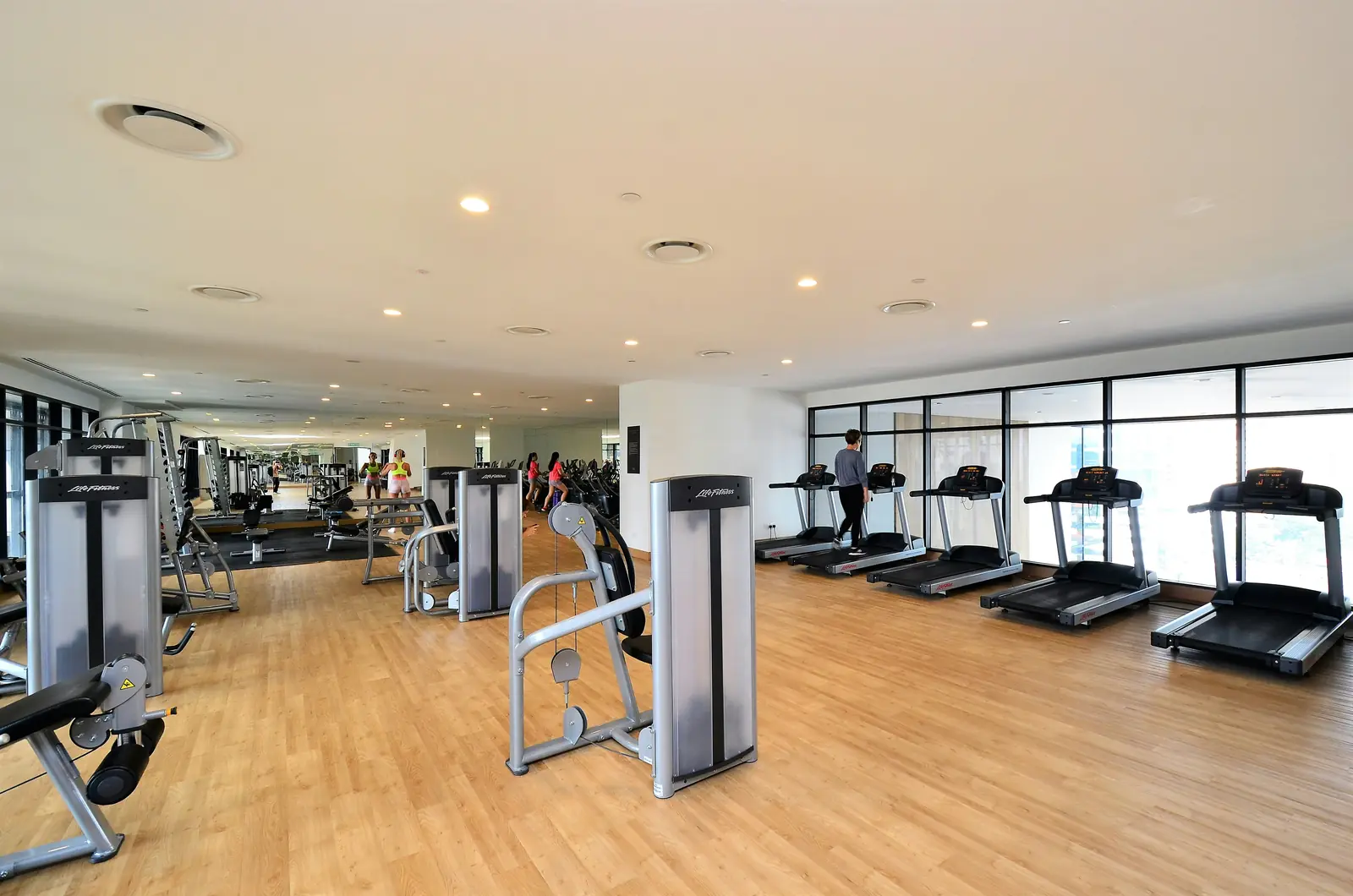 Betriebsmittelprüfung und Leiter- und Trittprüfung im Fitnessstudio: Heller Trainingsbereich mit Laufbändern.