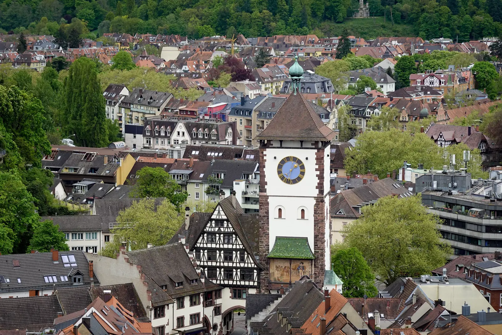Betriebsmittelprüfung und Leiter- und Trittprüfung in Freiburg: Torturm mit Uhr zwischen Fachwerkdächern.