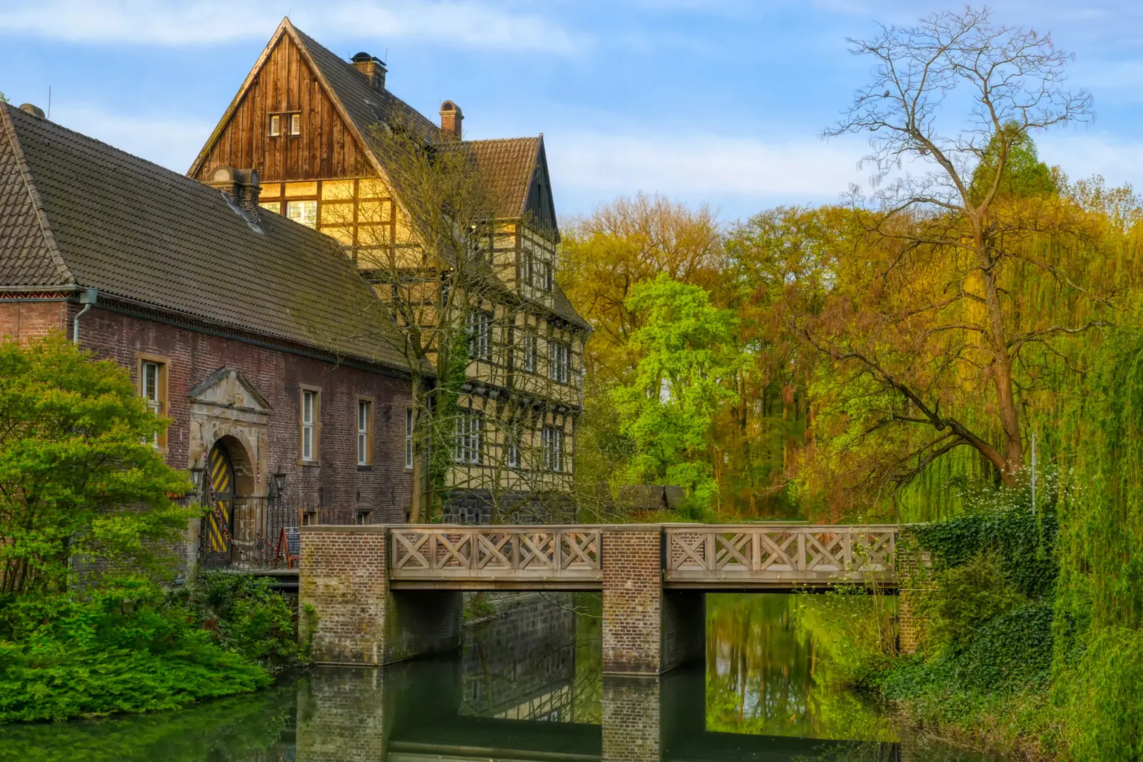 Betriebsmittelprüfung und Leiter- und Trittprüfung in Gladbeck: Fachwerkhaus und Steinbrücke am Wassergraben.