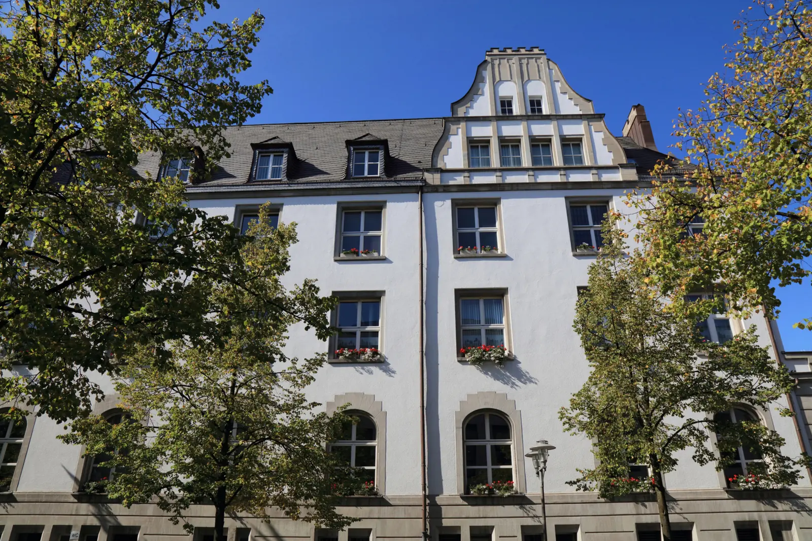 Betriebsmittelprüfung und Leiter- und Trittprüfung in Gladbeck: Giebelfassade mit Straßenleuchte am Platz.