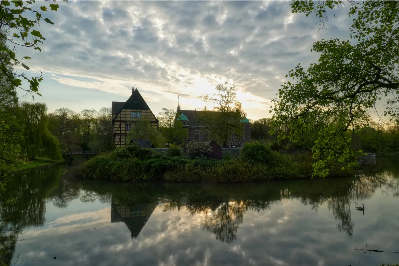 Betriebsmittelprüfung und Leiter- und Trittprüfung in Gladbeck: Schlossinsel im Gegenlicht des Sonnenuntergangs.
