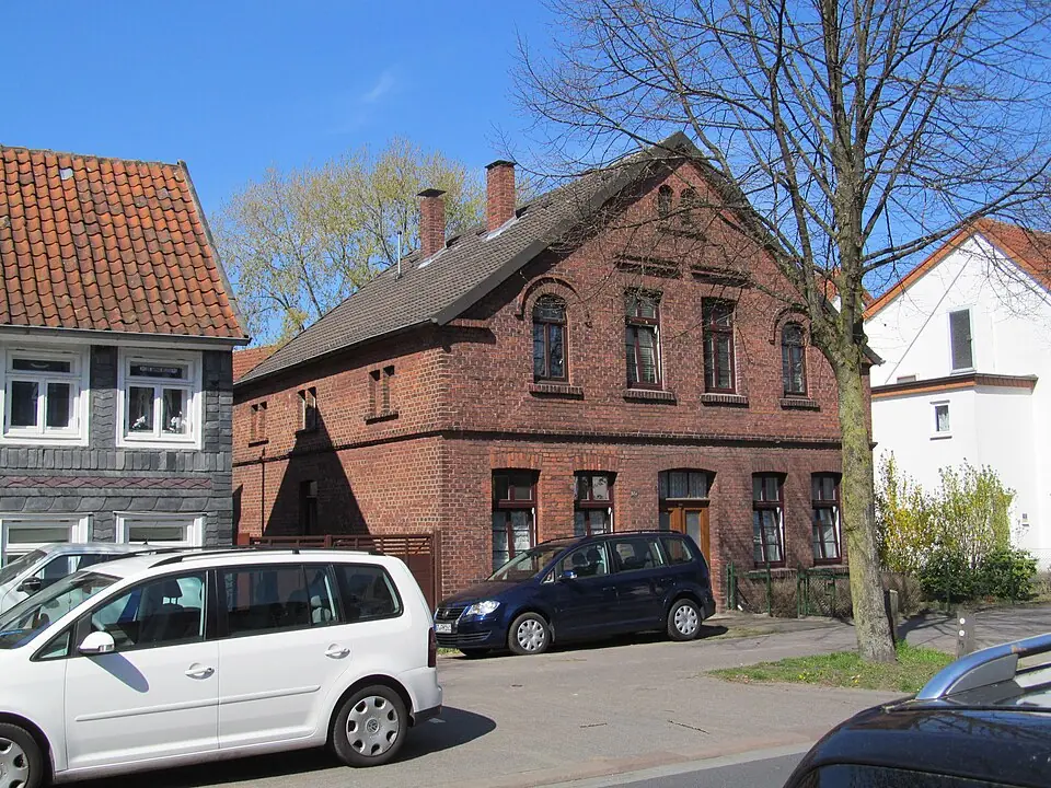 Betriebsmittelprüfung und Leiter- und Trittprüfung in Gütersloh: Backsteinhaus an einer Wohnstraße.