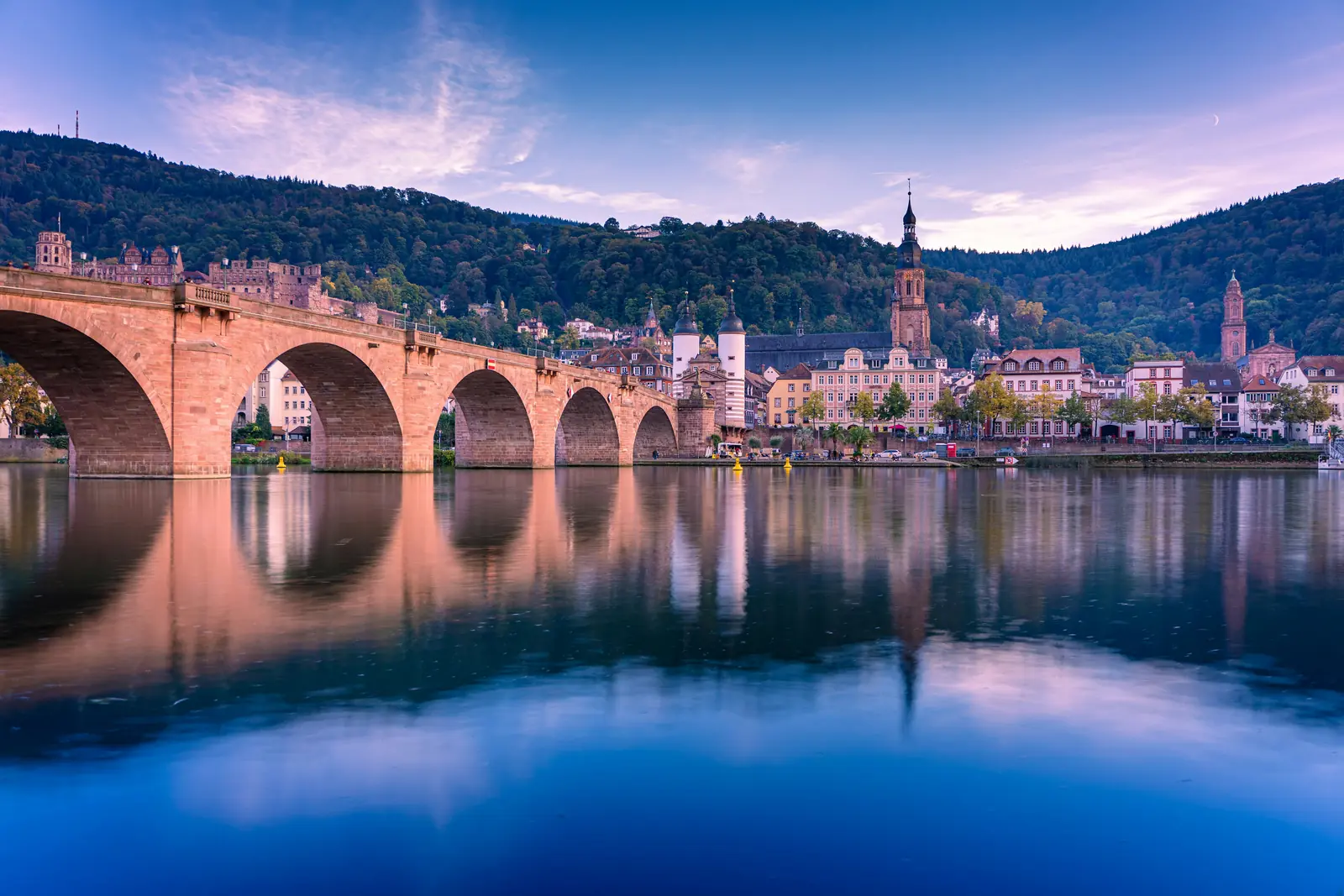 Betriebsmittelprüfung und Leiter- und Trittprüfung in Heidelberg: Steinbogenbrücke mit Spiegelung in der Dämmerung.