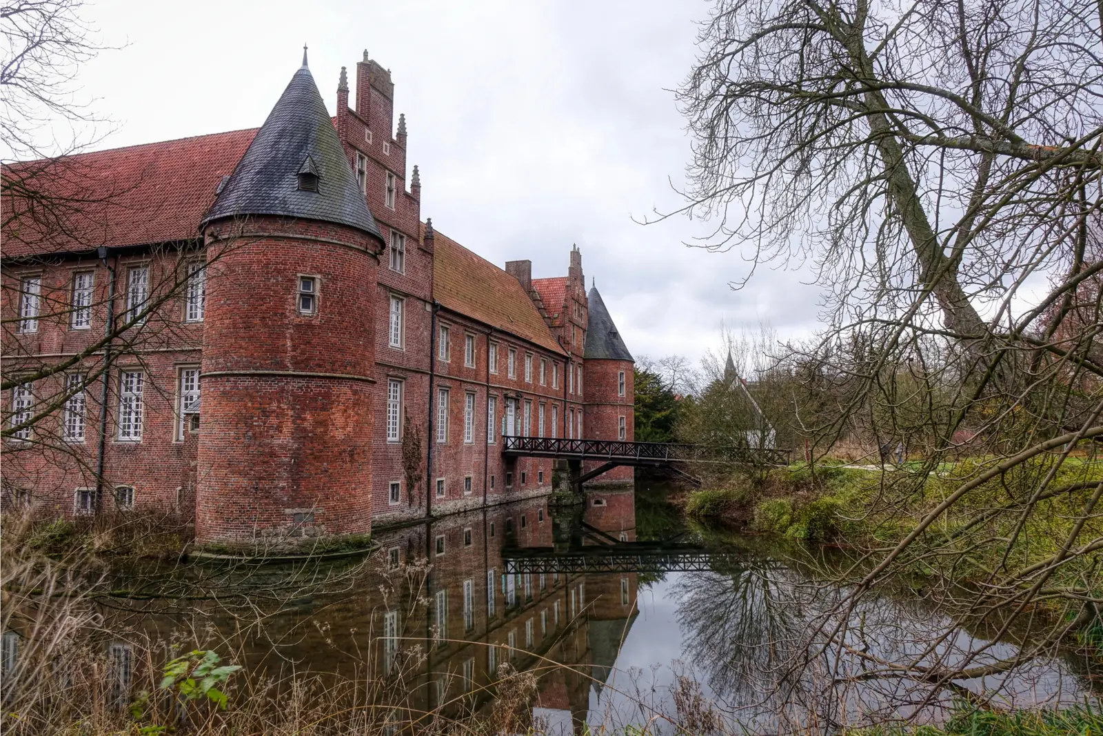 Betriebsmittelprüfung und Leiter- und Trittprüfung in Herten: Backsteinschloss mit Rundturm an der Gräfte.