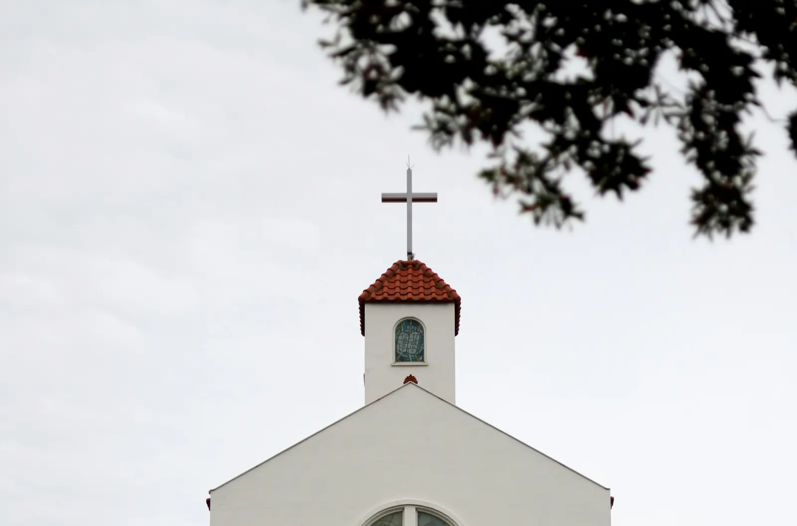 Betriebsmittelprüfung und Leiter- und Trittprüfung in der Kirche: Dachreiter mit Kreuz über dem Giebel.