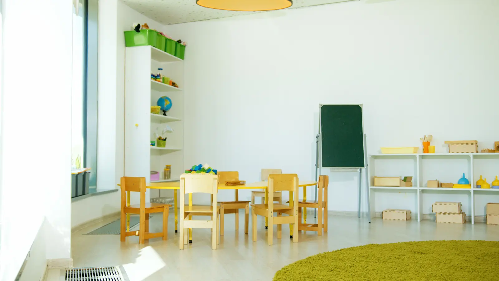 Betriebsmittelprüfung und Leiter- und Trittprüfung in der Kita: Gruppenraum mit Tafel und Materialregalen.
