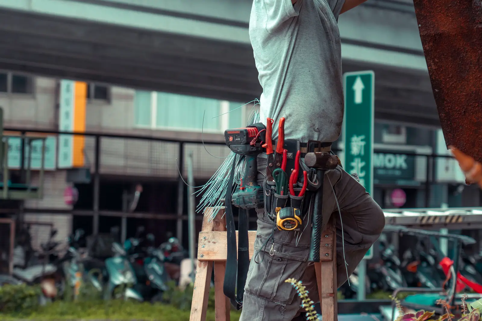 Leiter- und Trittprüfung im Baumarkt: Handwerker arbeitet auf einer Holzleiter.
