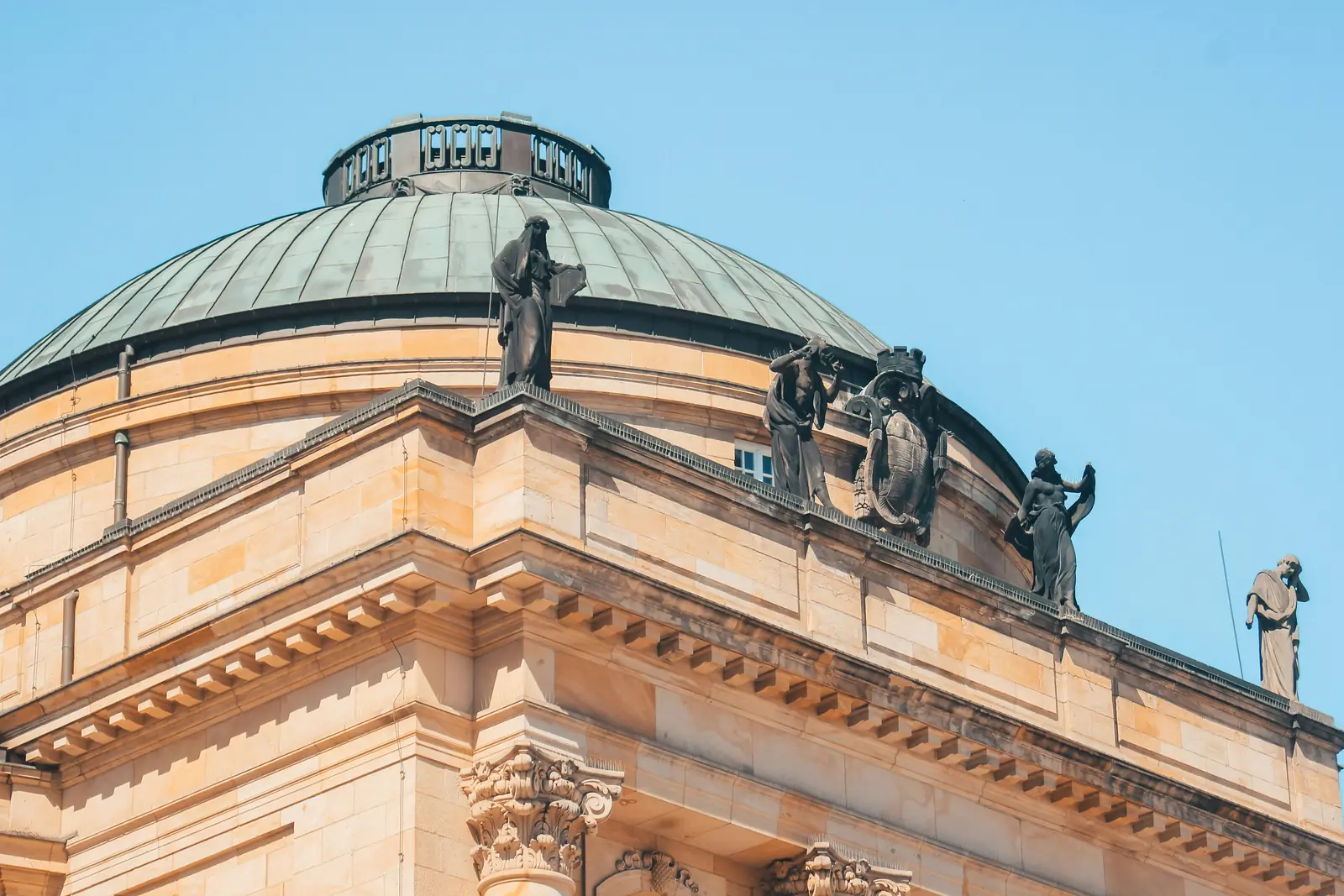 Leiter- und Trittprüfung in Chemnitz: Dachfiguren auf dem Gesims eines Kuppelbaus.