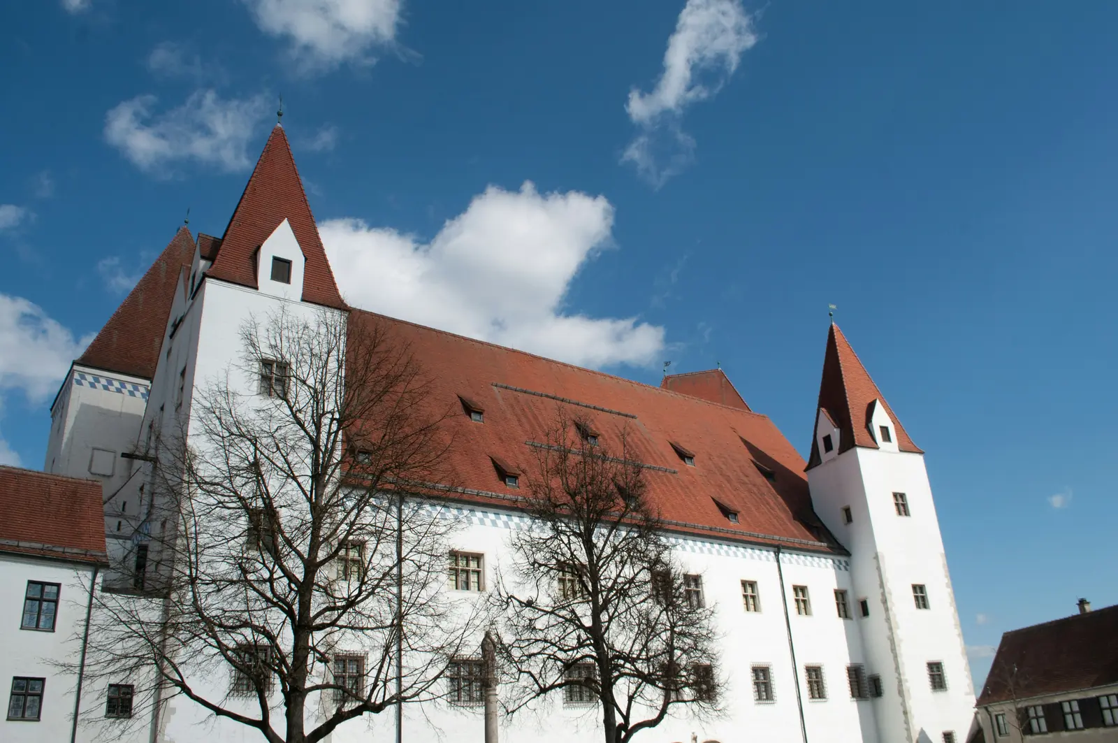 Leiter- und Trittprüfung in Ingolstadt: Steiles Ziegeldach und Ecktürme eines Schlossbaus.